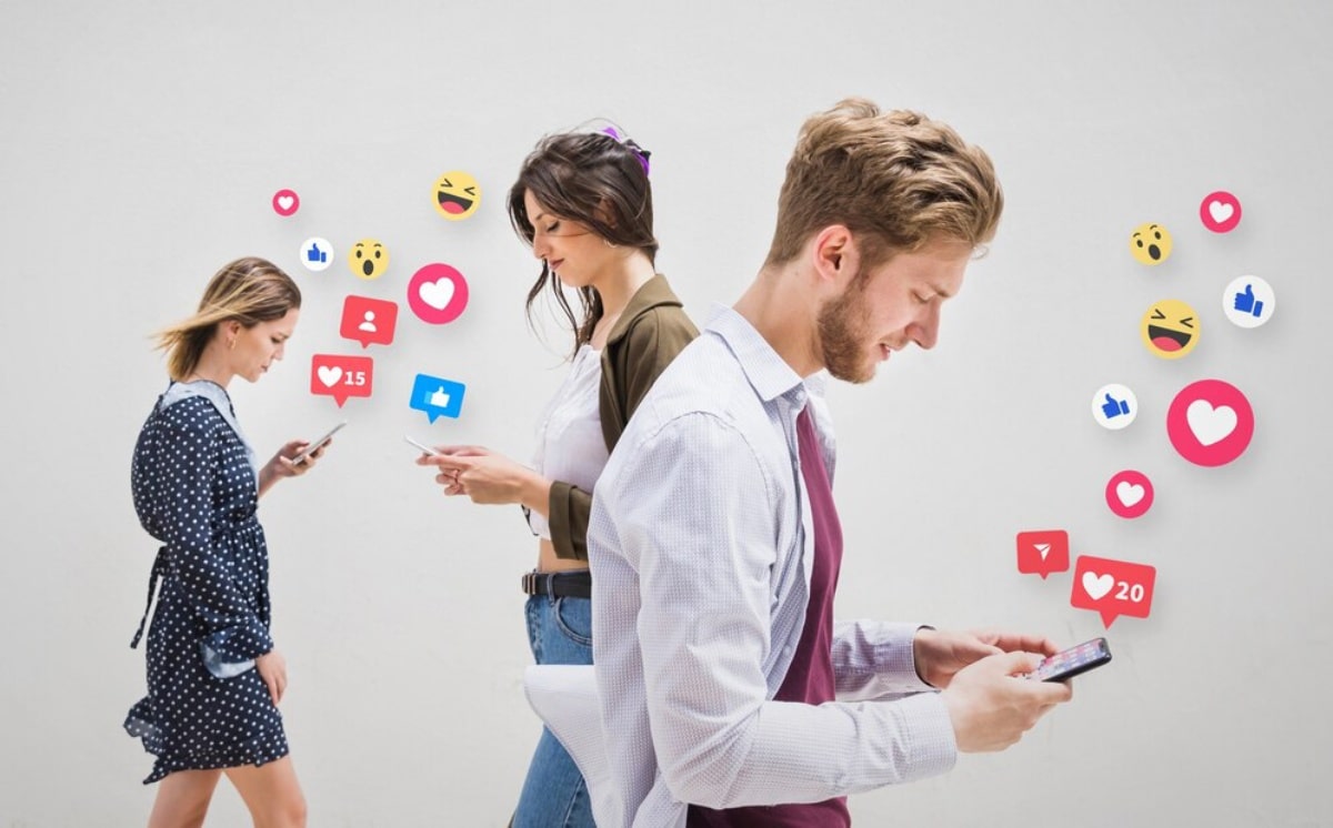 A group of individuals poses in front of a wall adorned with social media icons, showcasing diversity and engagement.